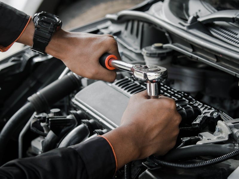Technician working in the engine block of a vehicle